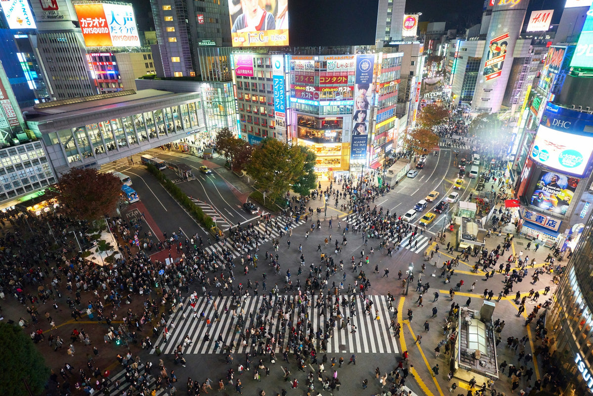 Crowds crossing the Shibuya scramble crossing in Tokyo at night
