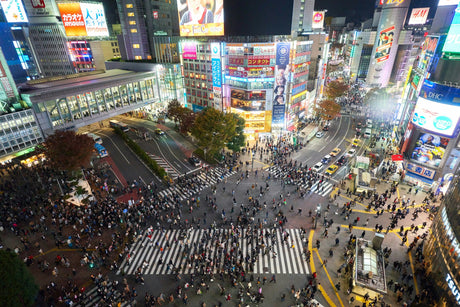 Crowds crossing the Shibuya scramble crossing in Tokyo at night